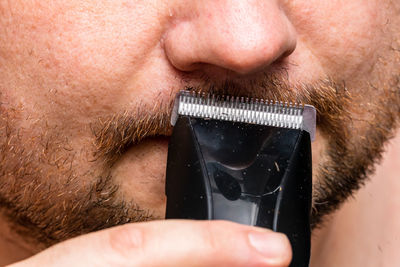 Close-up of man shaving