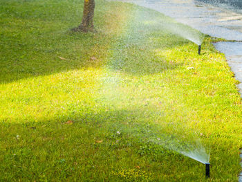 High angle view of water sprinklers by footpath at park