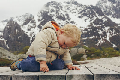 Boy against snowcapped mountain