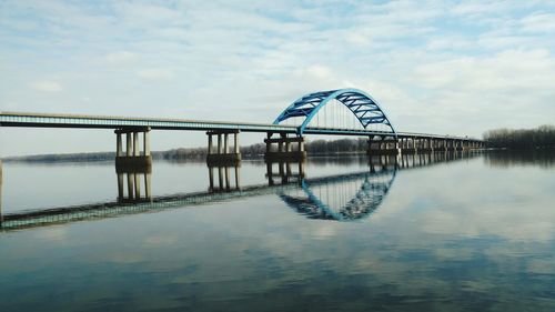 Bridge reflecting in mississippi river against sky