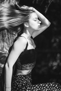 Beautiful young woman sitting outdoors