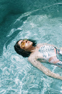 High angle view of woman relaxing in swimming pool