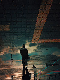 Rear view of silhouette man standing by wall