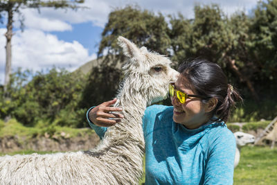 Woman hugging an alpaca, cusco, peru, south america