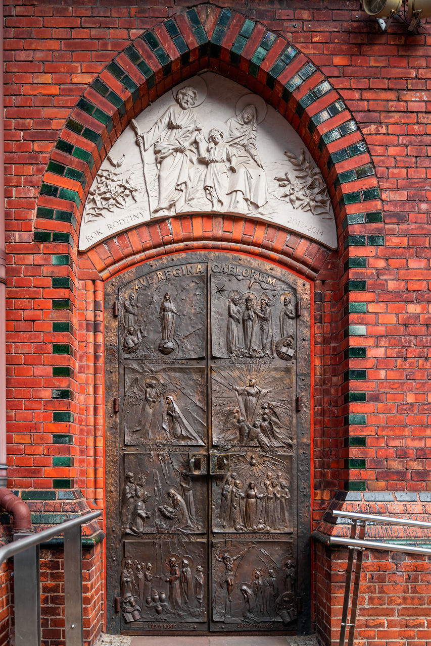 VIEW OF ORNATE DOOR ON BRICK WALL WITH BUILDING