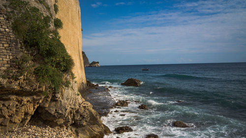 Built structure by sea against sky