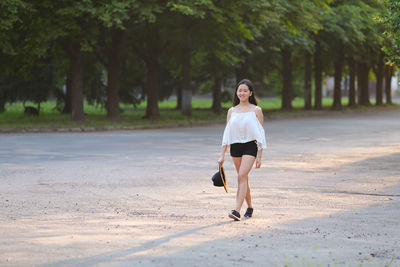 Full length of young woman running on road