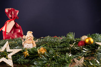 Close-up of christmas decorations on tree against black background