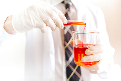 Close-up of hand pouring drink in glass