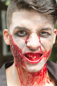 Close-up portrait of spooky man with blood on face during halloween