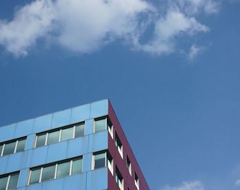 Low angle view of modern building against blue sky