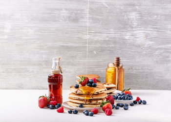 Various fruits in glass bottles on shelf