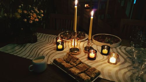 Lit candle in dark room