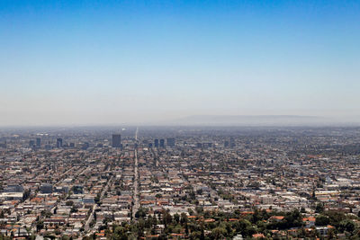 High angle view of buildings in city against clear blue sky