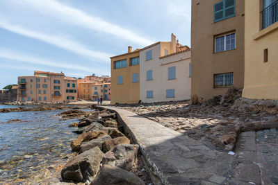 Buildings by sea against sky