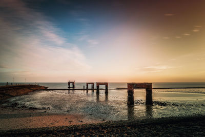 Scenic view of beach against sky during sunset