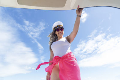 A woman on top of a boat against the sea in the background. 