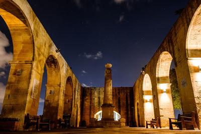 Low angle view of illuminated building against sky at night