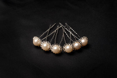 Close-up of pearl hairpins on black textile