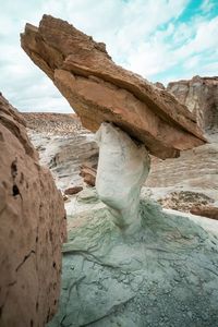 Rock formation on beach against sky