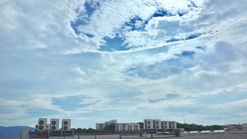 View of cityscape against cloudy sky