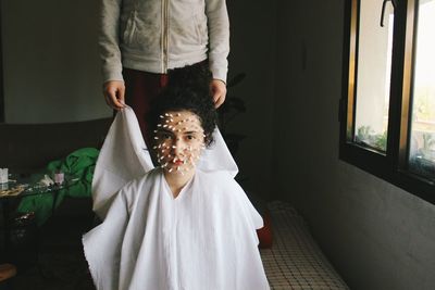 Close-up of bride with cotton swab on face