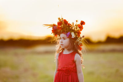 Cute girl wearing flowers during sunset