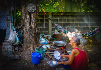 Side view of woman sitting at yard