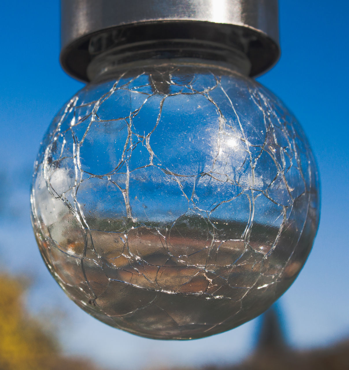 CLOSE-UP OF GLASS BALL AGAINST BLUE BACKGROUND