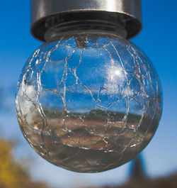 Close-up of glass against blue sky