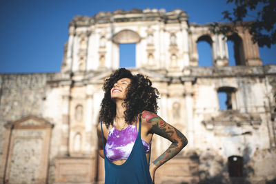 Smiling woman standing against historical building