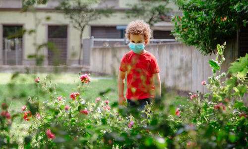 Boy plays outdoors in spring with mask
