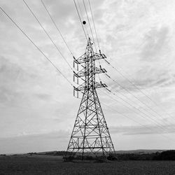 Low angle view of electricity pylon against sky