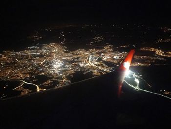 Aerial view of illuminated city against sky at night