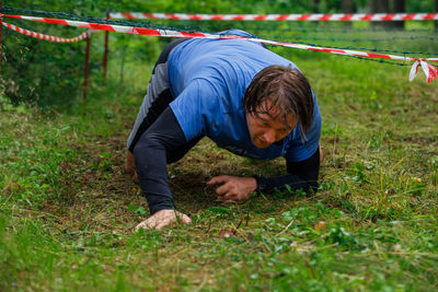 Rear view of man lying on field