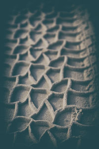 Full frame shot of tire tracks on sand