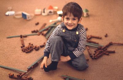 High angle portrait of boy playing with wooden toys on carpet