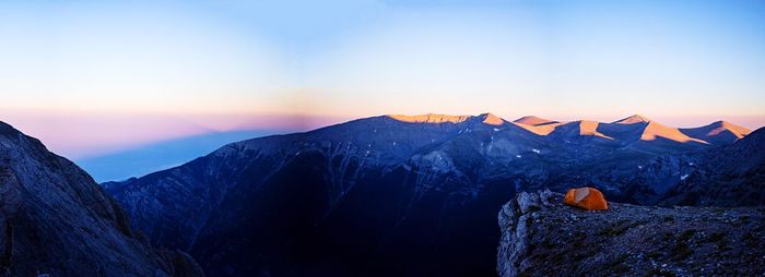 Scenic view of snow covered mountains at sunset