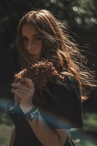 Portrait of young woman holding mask