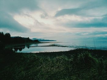 Scenic view of lake against sky at sunset