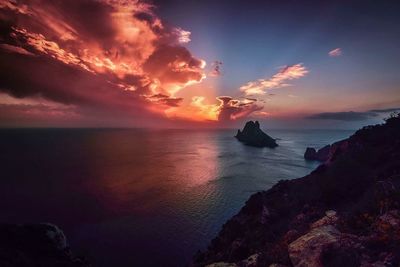 Scenic view of sea against dramatic sky during sunset