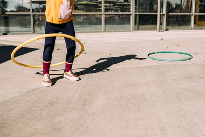 Girl hula hooping on a patio on a summer day