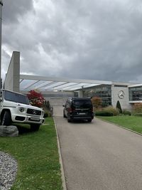 Cars on road against cloudy sky