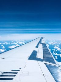 Aircraft wing against cloudy sky