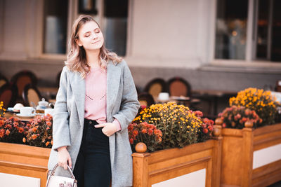 Teenager girl standing by flowering plants