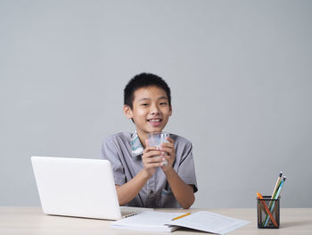 Young man using mobile phone while sitting on table