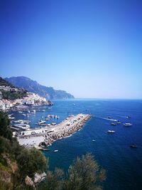 High angle view of sailboats in sea against clear blue sky