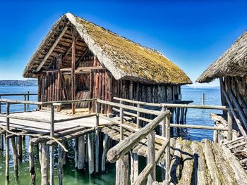 Panoramic shot of building by sea against clear blue sky