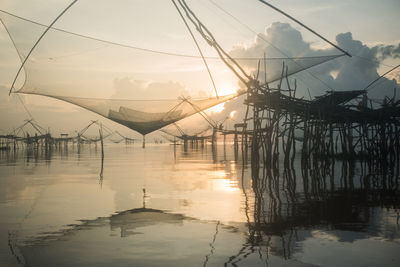 Bridge over sea against sky during sunset