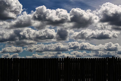 Scenic view of silhouette fence against sky